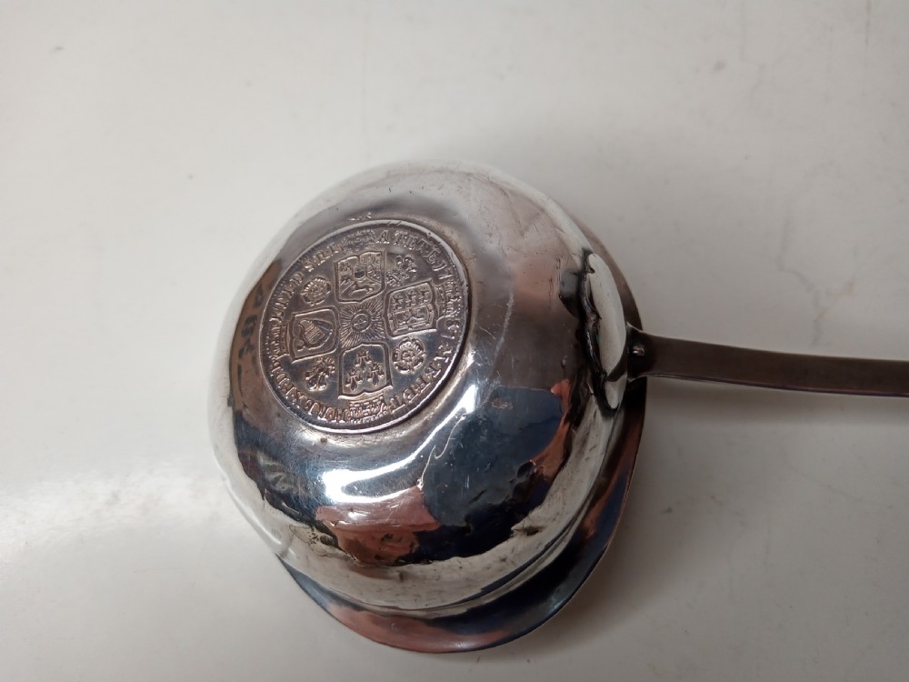 A Georgian silver toddy ladle bowl with an inset George III silver coin at the centre and a reeded handle joint. View VI