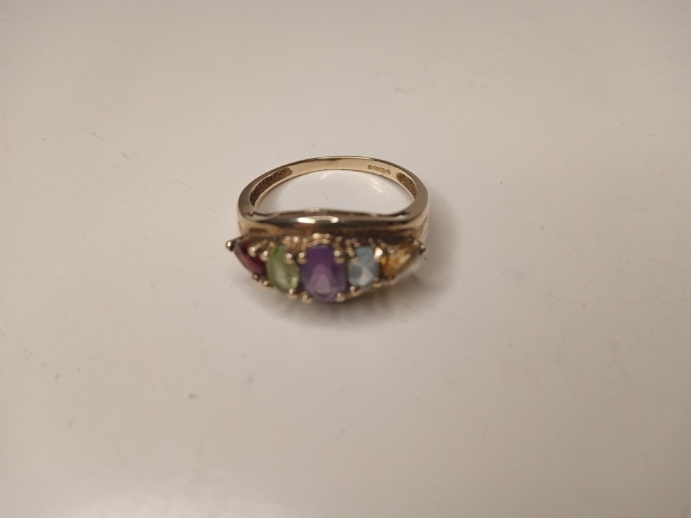 A nine-carat yellow gold ring featuring a horizontal row of five oval gemstones in varied colours within a boat-shaped mount. View II