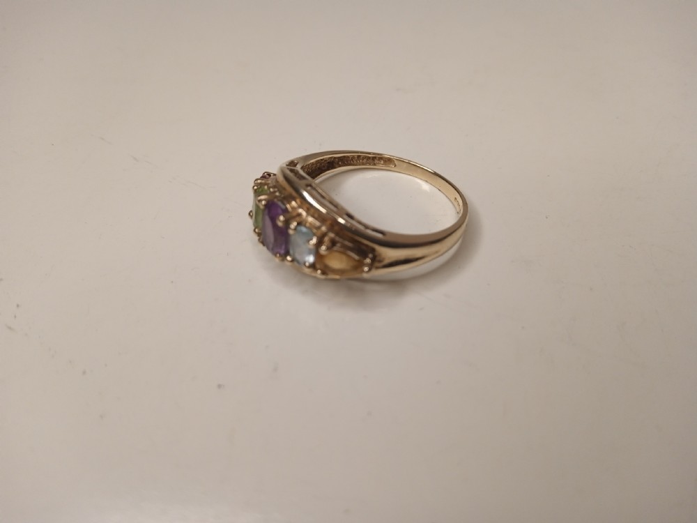 A nine-carat yellow gold ring featuring a horizontal row of five oval gemstones in varied colours within a boat-shaped mount. View III