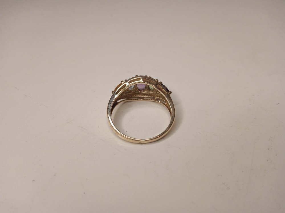 A nine-carat yellow gold ring featuring a horizontal row of five oval gemstones in varied colours within a boat-shaped mount. View V