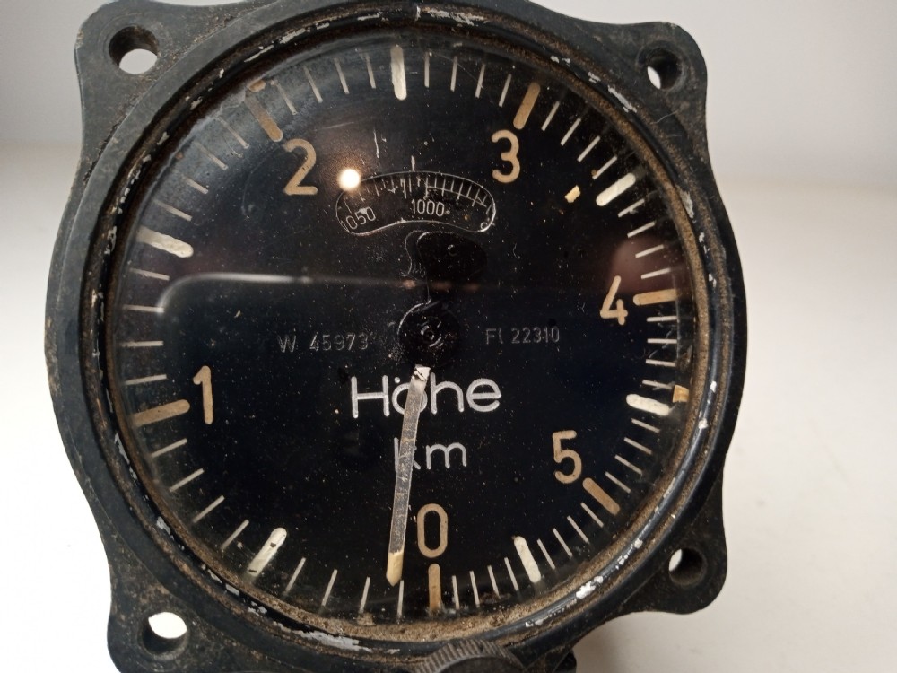 A square black metal Second World War German Luftwaffe aircraft altimeter gauge featuring white dial numbers from zero to five and a central adjustment knob. View II