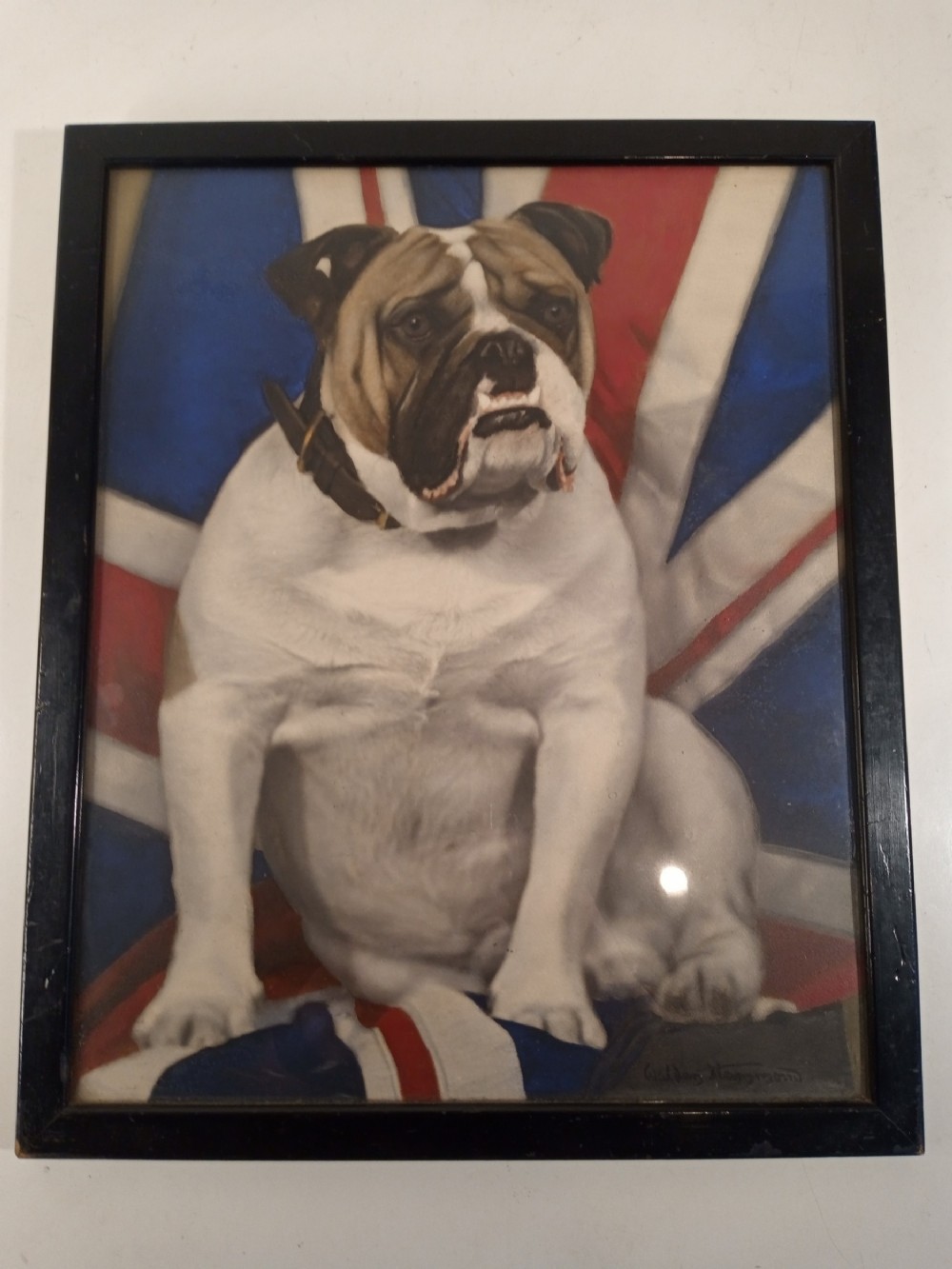 A framed 1940s portrait depicting an English bulldog sitting in front of a Union Jack flag inside a dark wooden frame.