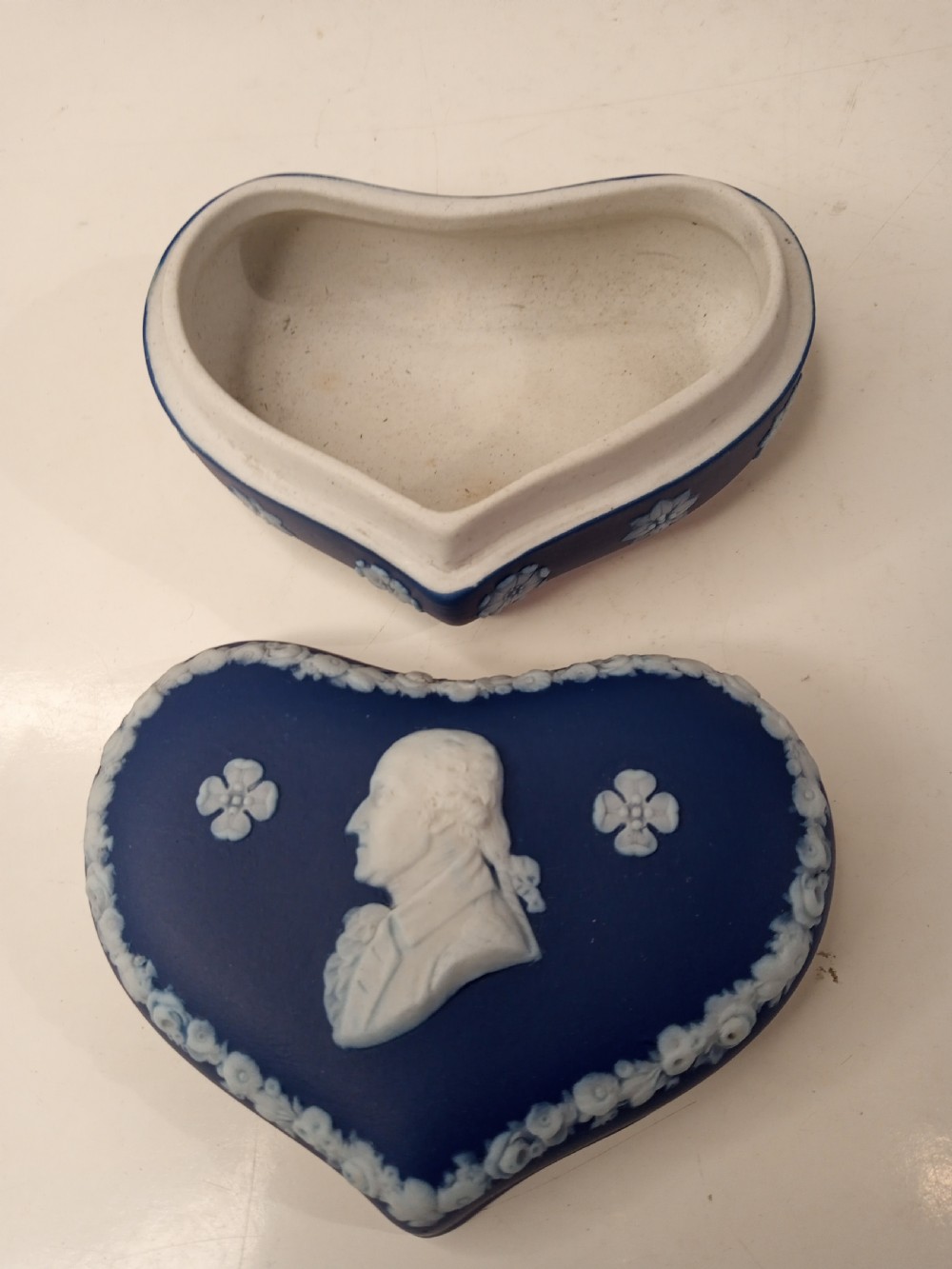 A heart-shaped dark blue Jasperware trinket box lid featuring a white bas-relief profile portrait bust surrounded by floral border accents. View III