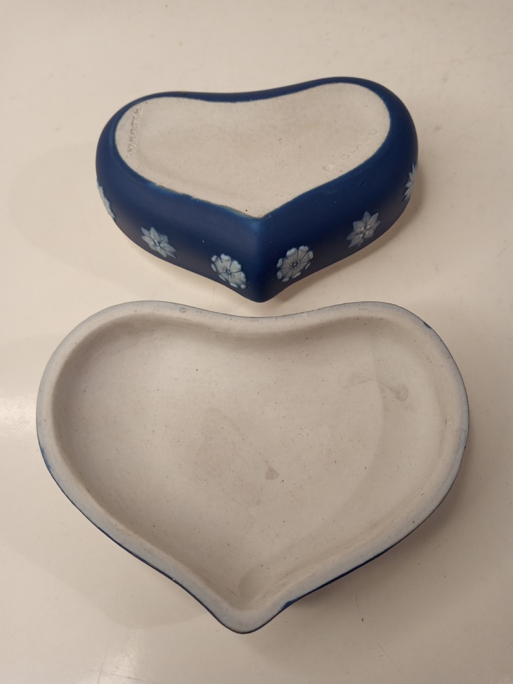 A heart-shaped dark blue Jasperware trinket box lid featuring a white bas-relief profile portrait bust surrounded by floral border accents. View IV