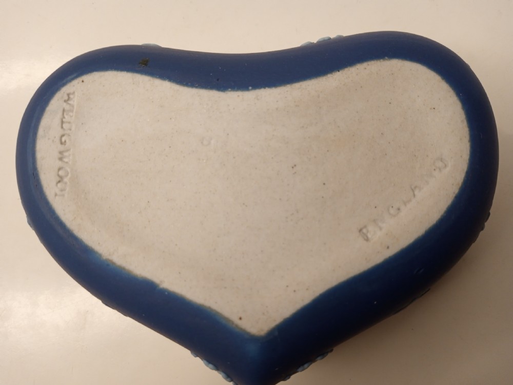 A heart-shaped dark blue Jasperware trinket box lid featuring a white bas-relief profile portrait bust surrounded by floral border accents. View V
