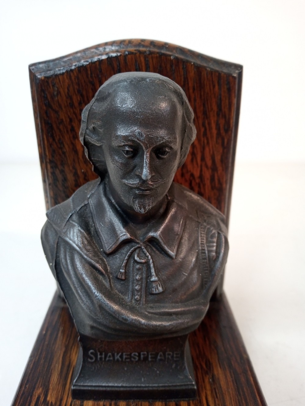 A pair of Art Deco bookends featuring metal busts of William Shakespeare mounted on dark oak bases. View V