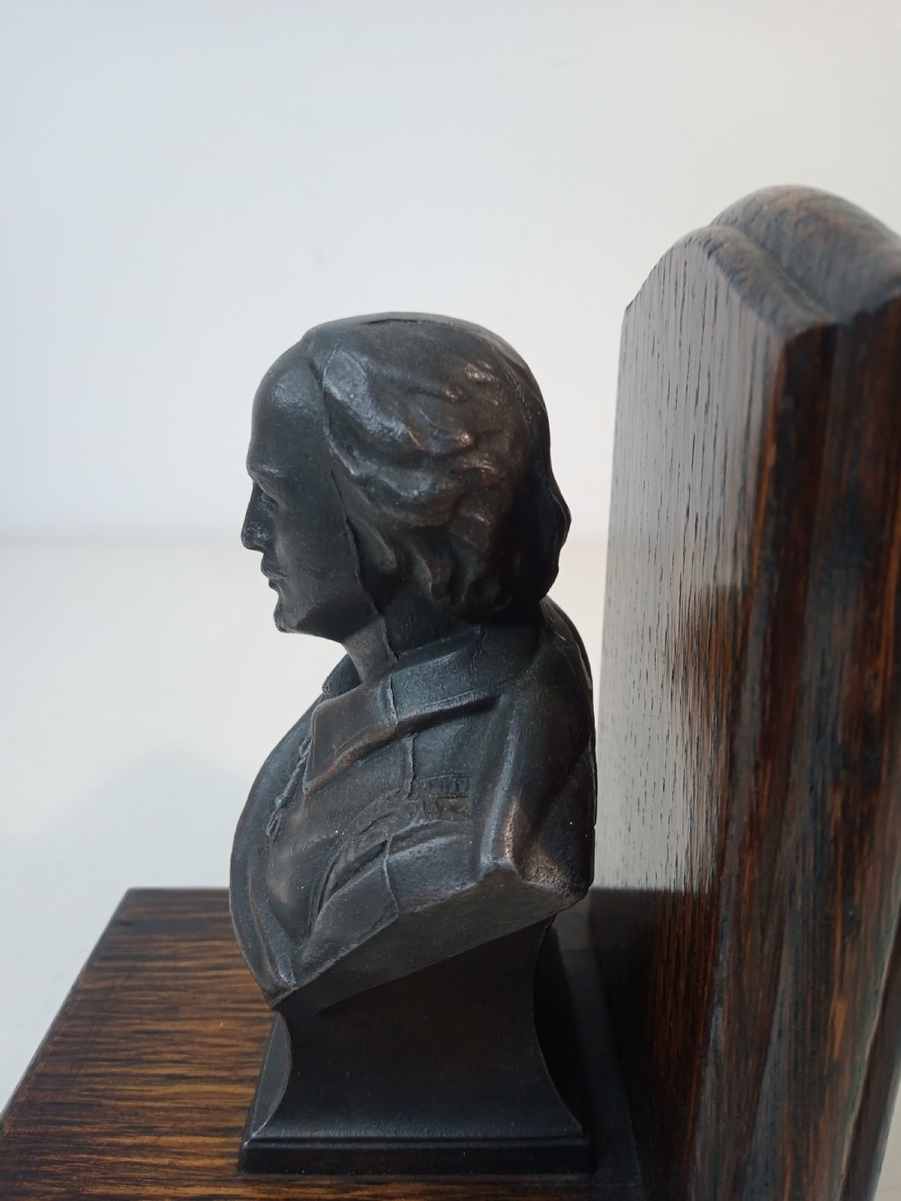 A pair of Art Deco bookends featuring metal busts of William Shakespeare mounted on dark oak bases. View VII