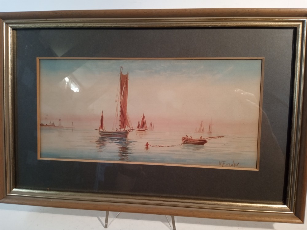 A horizontal nineteenth-century Victorian watercolour painting depicting reddish-brown sailing vessels on calm blue water with a distant lighthouse, housed in a double mount and wooden frame. View II