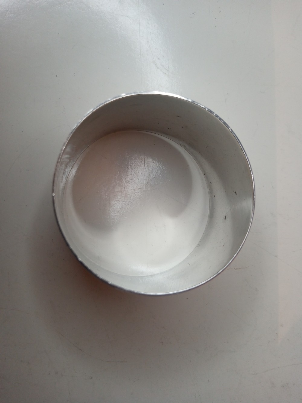 A plain circular sterling silver napkin ring displaying stamped official hallmarks on the polished outer surface. View III