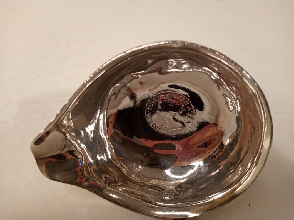 A mid-eighteenth century sterling silver punch ladle featuring a deep circular silver bowl and a long twisted dark handle. View VIII