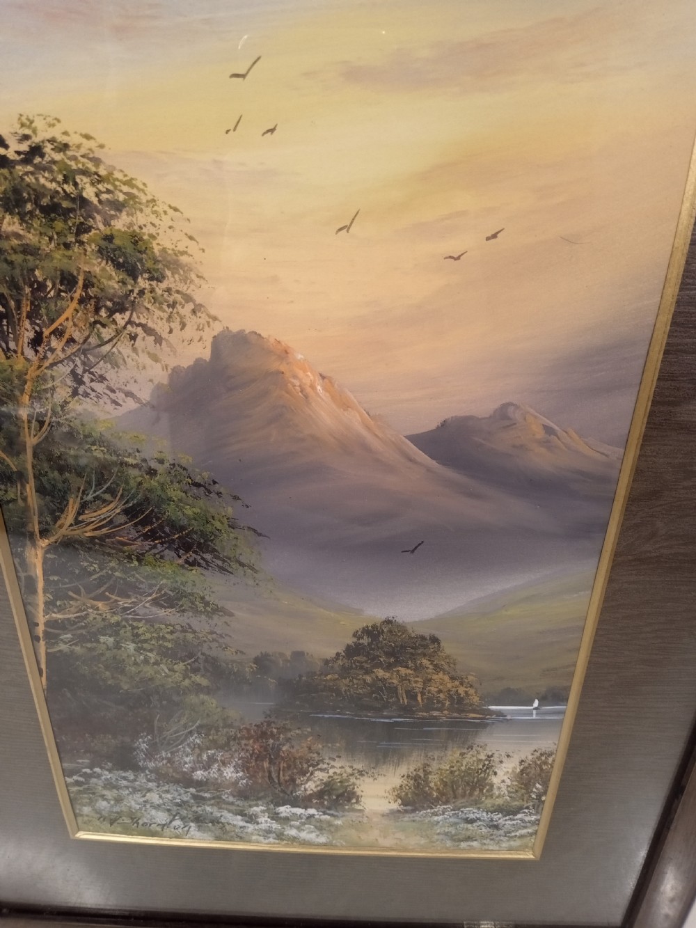 A pair of framed early 20th-century gouache landscape paintings depicting mountainous scenes with bodies of water framed in dark wooden mounts and frames. View V