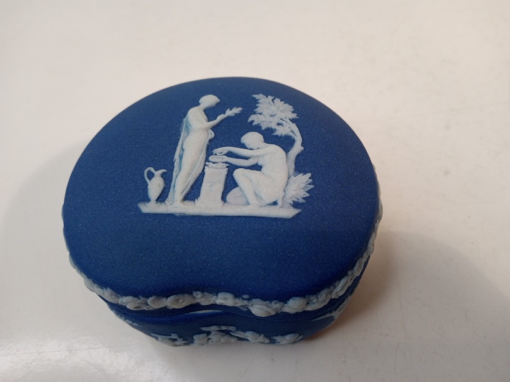 A pair of kidney-shaped blue Wedgwood jasperware trinket boxes with white classical bas-relief scenes on their lids. View IV