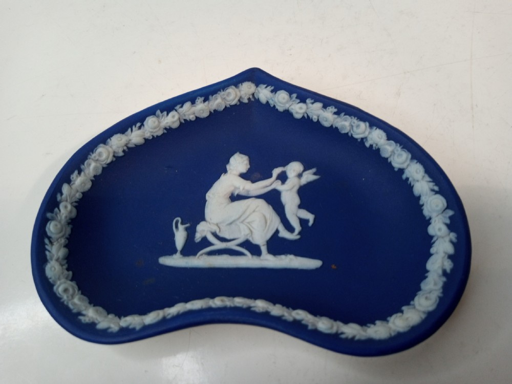 A dark blue Wedgwood jasperware heart-shaped tray alongside a matching circular ring stand featuring white classical bas-relief motifs. View IV