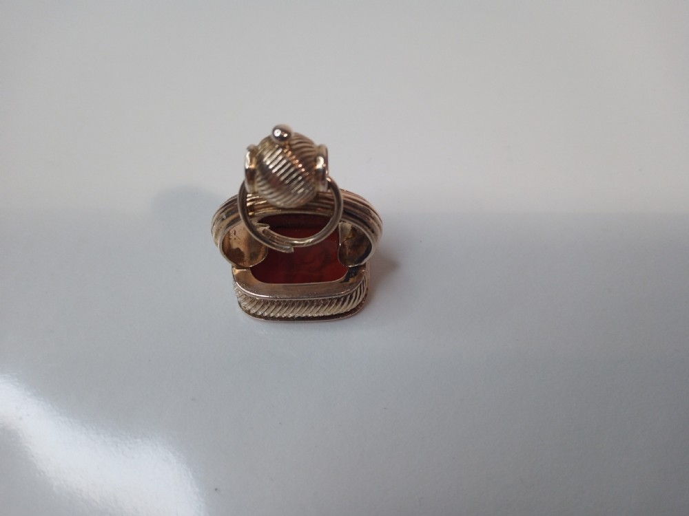 A 9 carat yellow gold watch fob seal featuring a textured gadrooned handle set with a rectangular reddish-brown carnelian stone base. View III