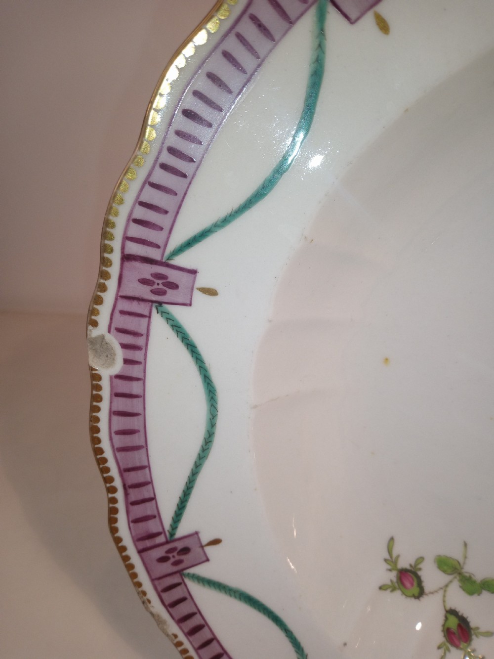 A set of five mid-18th-century Georgian Chelsea soft-paste porcelain plates and shallow bowls decorated with painted floral sprays and pink diaper borders. View X