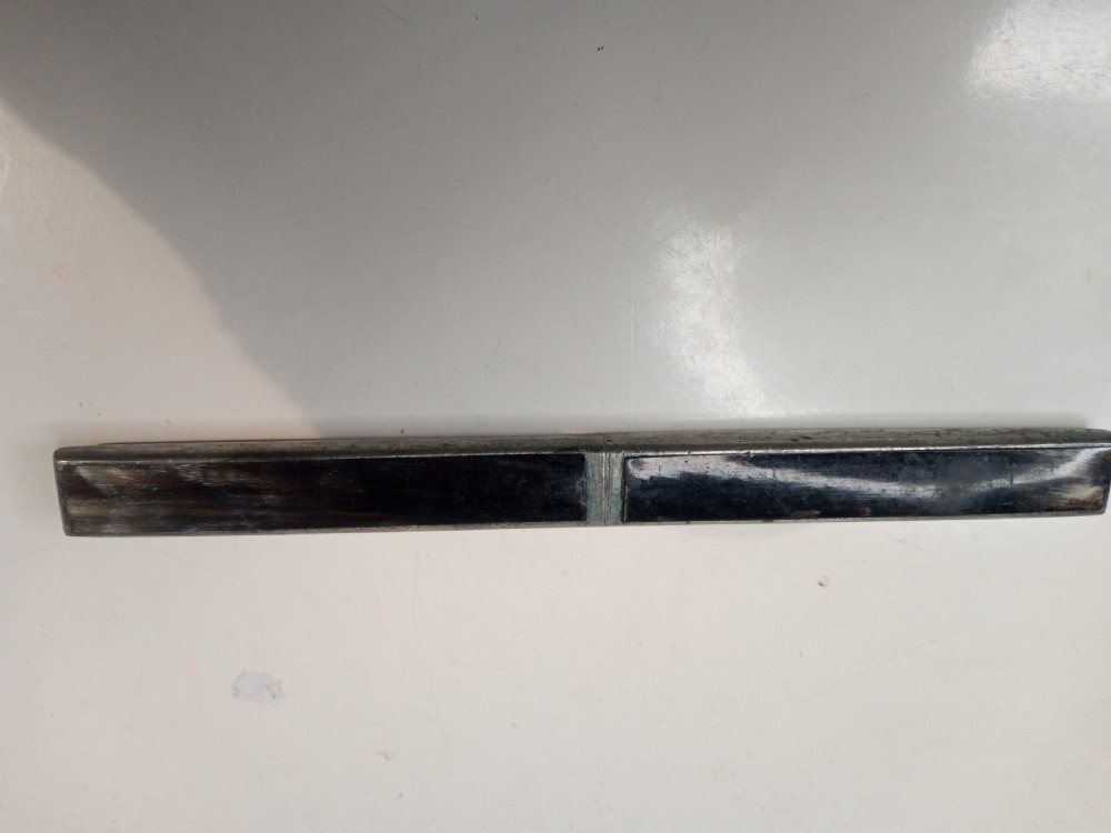 A closed rectangular nineteenth-century campaign cutlery casing featuring dark horn panels within a slim metal border. View II