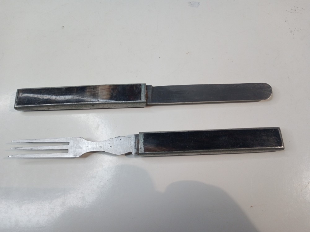 A closed rectangular nineteenth-century campaign cutlery casing featuring dark horn panels within a slim metal border. View VI