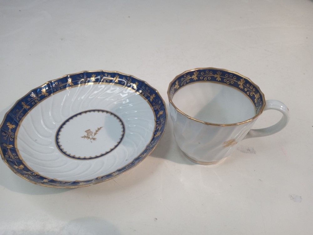 A Georgian Worcester spiral-fluted porcelain teacup and saucer with cobalt blue and gilt foliate borders. View III
