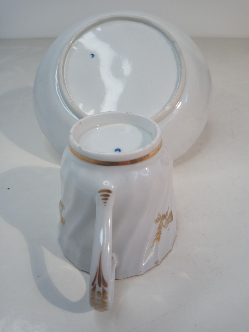 A Georgian Worcester spiral-fluted porcelain teacup and saucer with cobalt blue and gilt foliate borders. View IV
