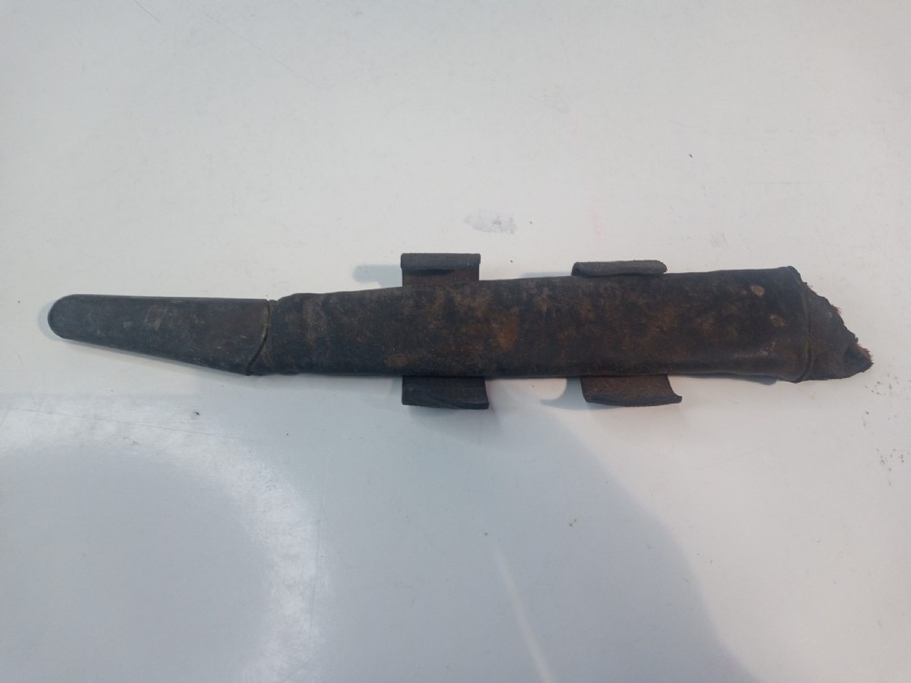 A World War II double-edged commando fighting knife with a ribbed handle positioned below its dark leather scabbard. View V