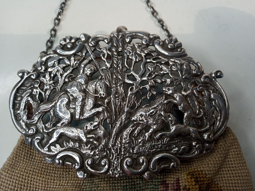 Late Victorian sterling silver evening purse featuring a pierced silver frame with a chain handle and a beige petit point needlepoint pouch with pink and yellow floral embroidery. View III