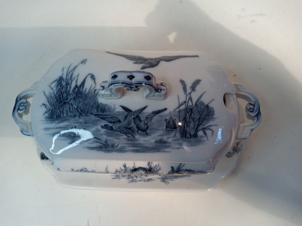 A Victorian Staffordshire earthenware tureen and matching stand with blue and white transferware illustrations of waterfowl and rabbits. View II