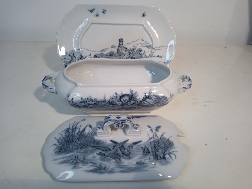 A Victorian Staffordshire earthenware tureen and matching stand with blue and white transferware illustrations of waterfowl and rabbits. View IV