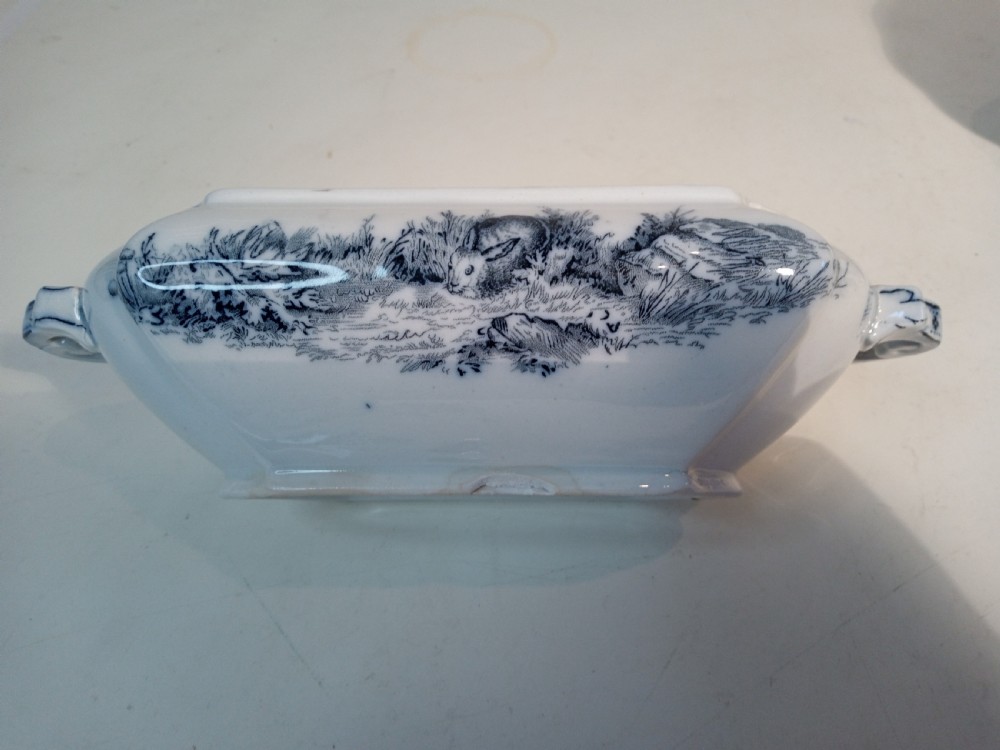A Victorian Staffordshire earthenware tureen and matching stand with blue and white transferware illustrations of waterfowl and rabbits. View V