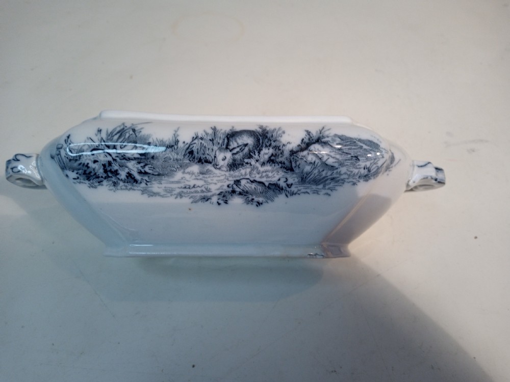 A Victorian Staffordshire earthenware tureen and matching stand with blue and white transferware illustrations of waterfowl and rabbits. View VI