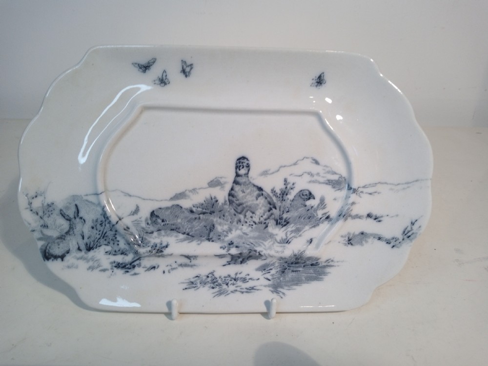 A Victorian Staffordshire earthenware tureen and matching stand with blue and white transferware illustrations of waterfowl and rabbits. View IX