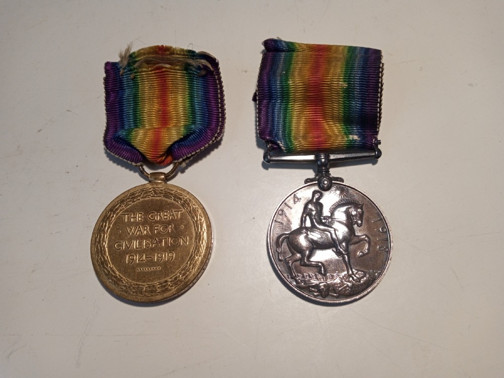 A pair of British First World War campaign medals including a bronze Victory Medal and a silver British War Medal with fabric ribbons. View II