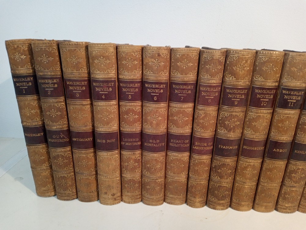 A complete set of 25 Victorian leather-bound Waverley Novels arranged side by side with gilt tooling and red title blocks along the spines. View II