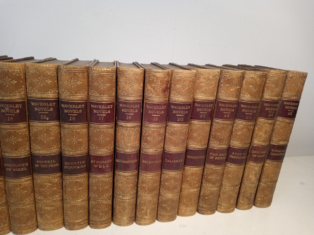 A complete set of 25 Victorian leather-bound Waverley Novels arranged side by side with gilt tooling and red title blocks along the spines. View IV