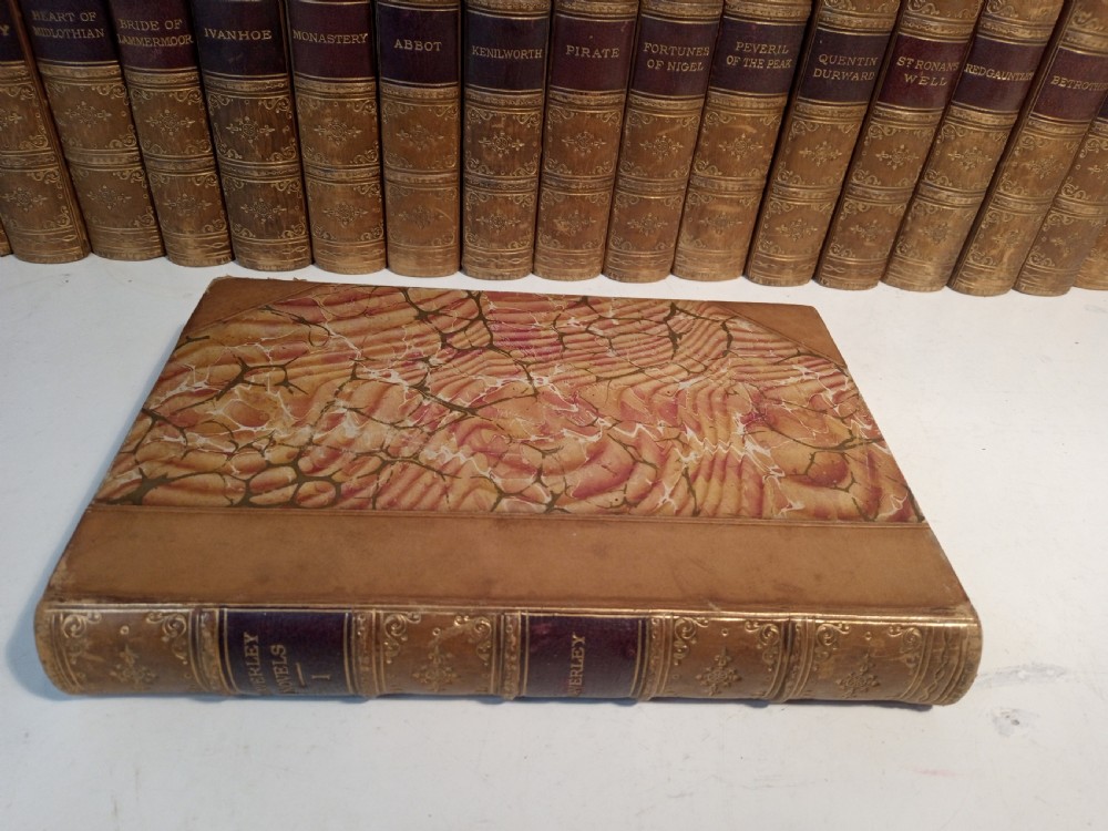 A complete set of 25 Victorian leather-bound Waverley Novels arranged side by side with gilt tooling and red title blocks along the spines. View V