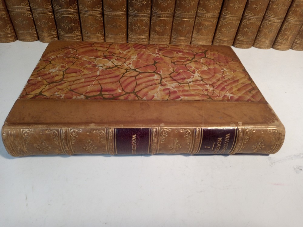 A complete set of 25 Victorian leather-bound Waverley Novels arranged side by side with gilt tooling and red title blocks along the spines. View VII