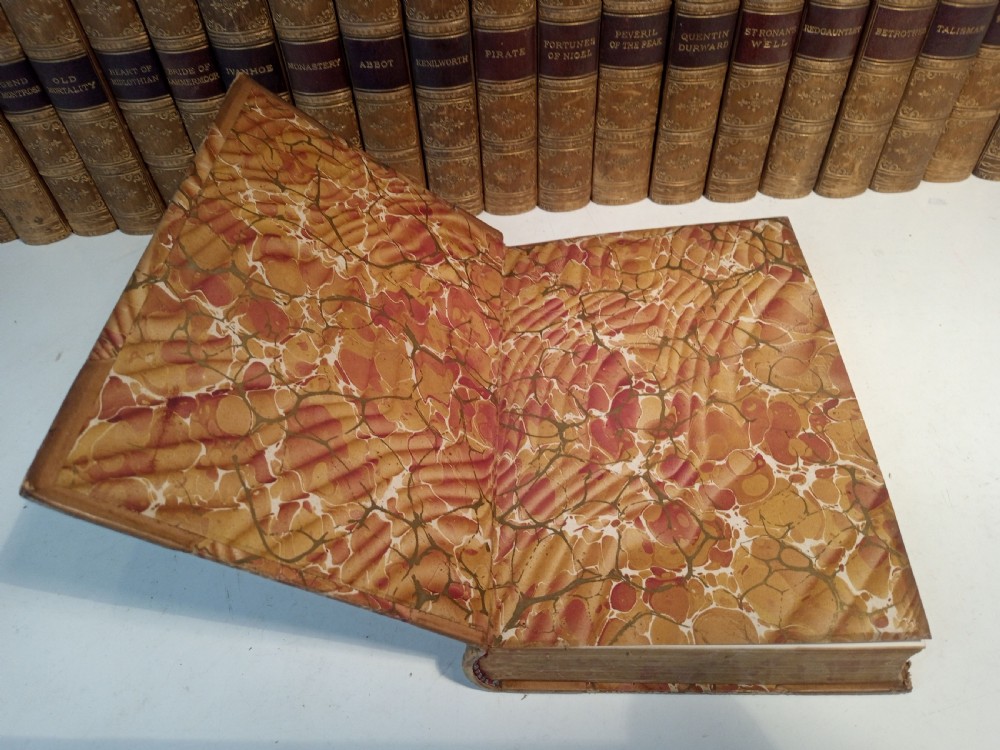 A complete set of 25 Victorian leather-bound Waverley Novels arranged side by side with gilt tooling and red title blocks along the spines. View IX
