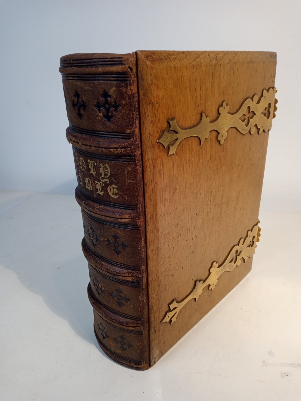 A mid-nineteenth-century Holy Bible featuring a brown leather spine with raised bands and ornate brass mounts over wooden covers. View II