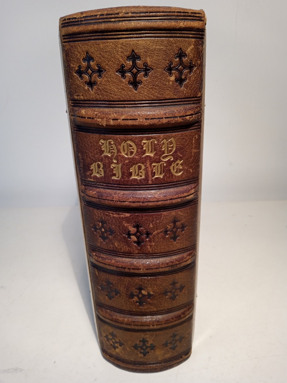 A mid-nineteenth-century Holy Bible featuring a brown leather spine with raised bands and ornate brass mounts over wooden covers. View III