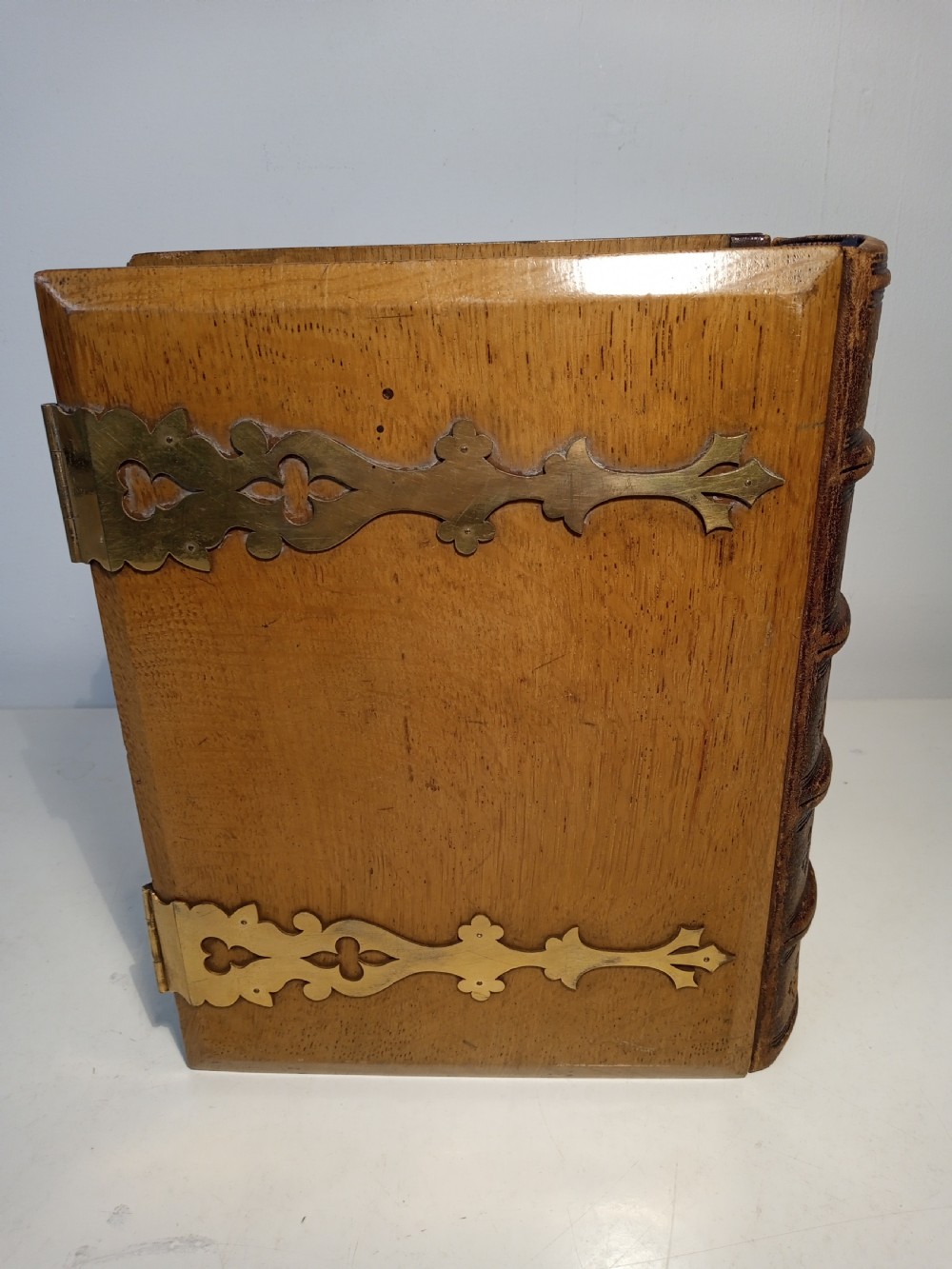 A mid-nineteenth-century Holy Bible featuring a brown leather spine with raised bands and ornate brass mounts over wooden covers. View IV