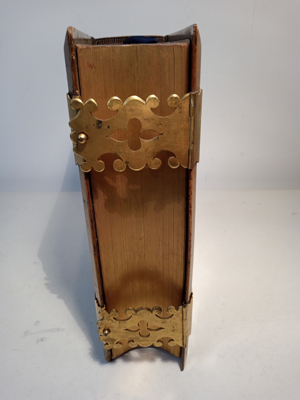 A mid-nineteenth-century Holy Bible featuring a brown leather spine with raised bands and ornate brass mounts over wooden covers. View VI