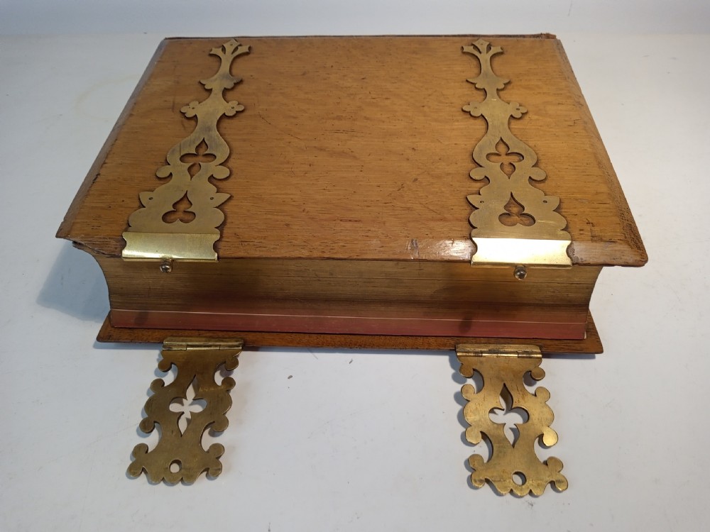 A mid-nineteenth-century Holy Bible featuring a brown leather spine with raised bands and ornate brass mounts over wooden covers. View IX
