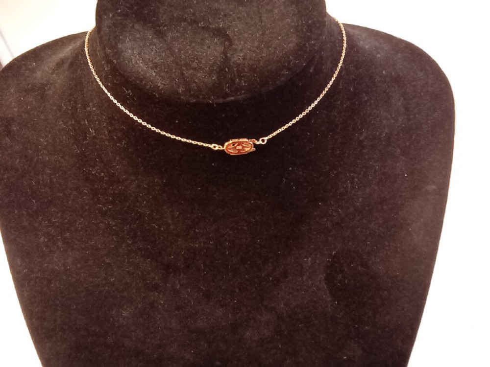 An Art Deco period gold chain necklace featuring a vertical drop pendant set with cabochon opals and small pearls. View II
