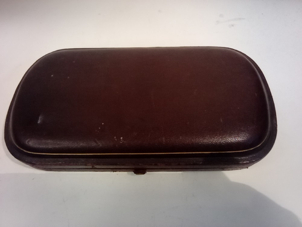 A dark presentation case lined with purple silk containing two embossed silver-gilt berry spoons and a pierced sugar sifter spoon. View III