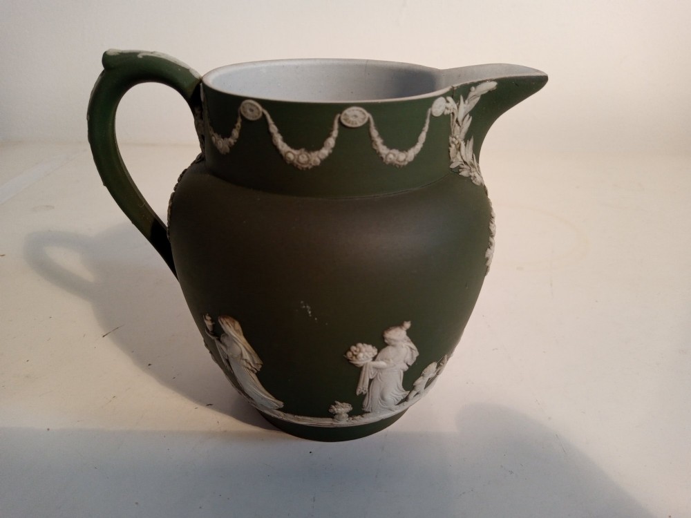 A late nineteenth-century three-piece olive green Wedgwood jasperware bachelor tea set adorned with white Neoclassical relief figures and foliage. View V