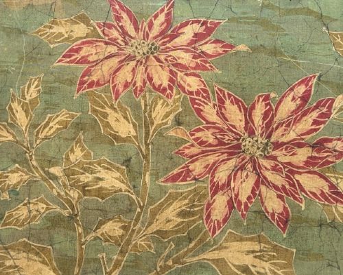 fig 4. A horizontal framed batik textile artwork displaying red and cream poinsettia flowers with foliage against a crackled sage green background.