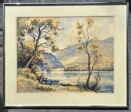 fig 1. A mid-20th-century watercolour landscape painting depicting a Cumbrian lake framed by foreground trees and distant mountains in tones of blue and ochre.