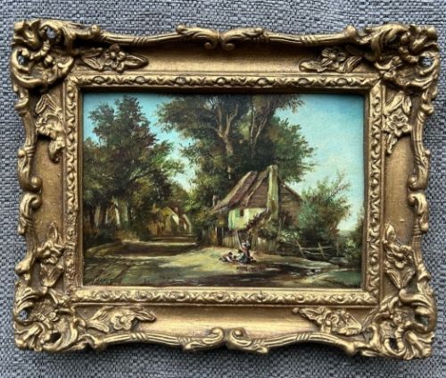 fig 1. An antique oil painting on panel depicting a rural British cottage surrounded by trees, set within an ornate gilt frame.