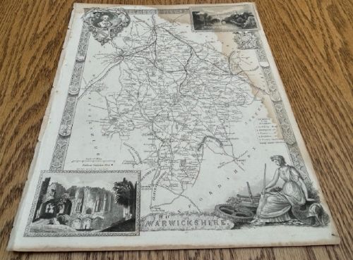 fig 1. A monochrome 19th-century steel-engraved map of Warwickshire featuring decorative architectural borders, vignette illustrations of Warwick Castle and Kenilworth Castle, and heraldic crests.