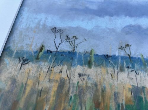 fig 3. A framed pastel painting depicting a grassy pathway through fields under a cloudy blue sky, housed in a dark frame with a light mount.