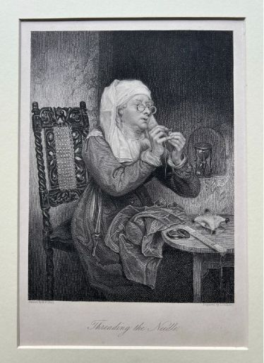 fig 2. A monochrome nineteenth-century steel engraving depicting an elderly woman wearing spectacles and a headscarf threading a needle while seated at a small wooden table.
